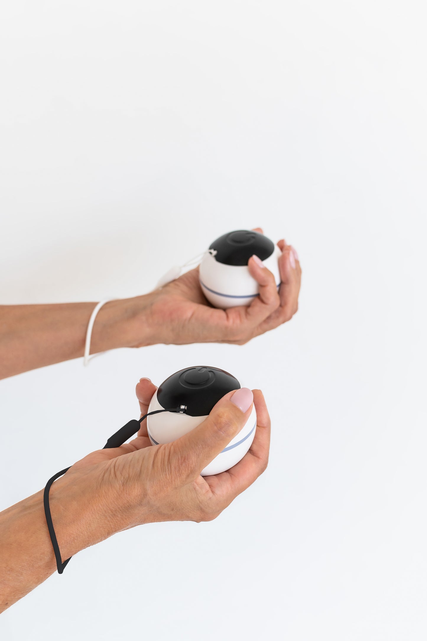 Habeo handheld device for essential tremor relief, being used in both hands. 