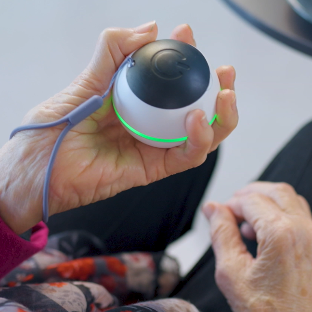 Habeo handheld device for essential tremor relief, being used by an older patient.